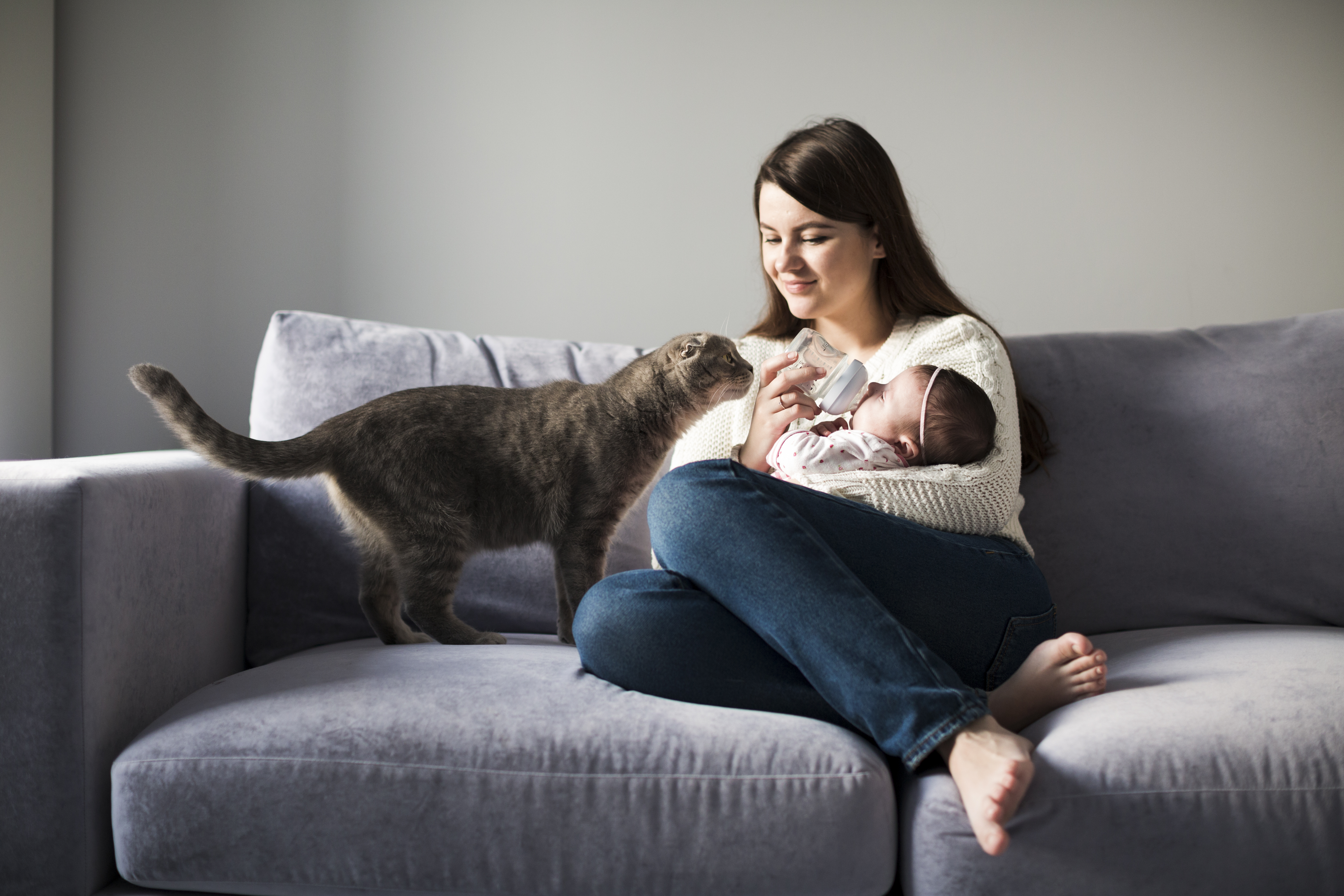 donna che allatta bambino divano